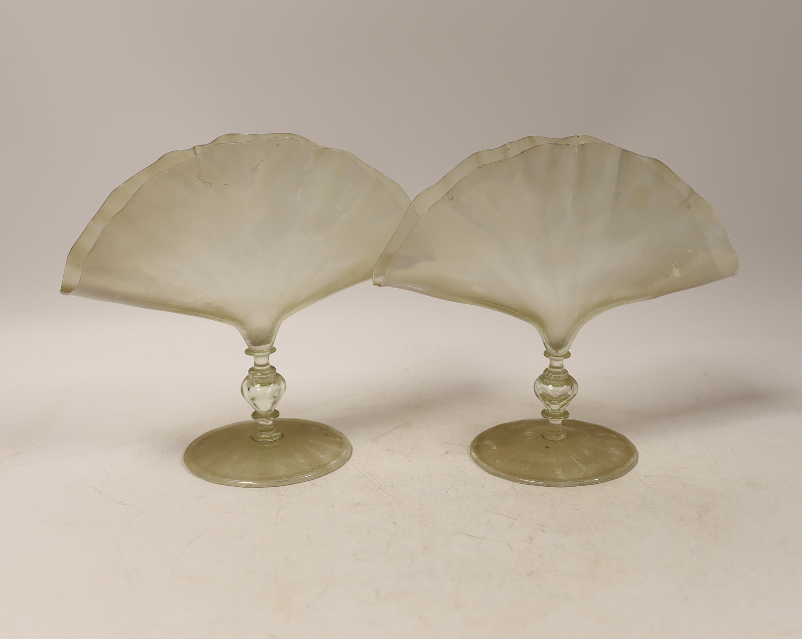 A pair of late 19th century vaseline glass fan shaped napkin holders on single knop stems, 16.5cm high x 19cm wide